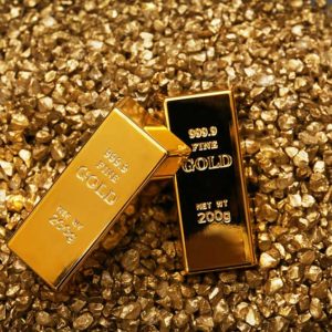 Gold Bars On Nugget Grains Background Close Up